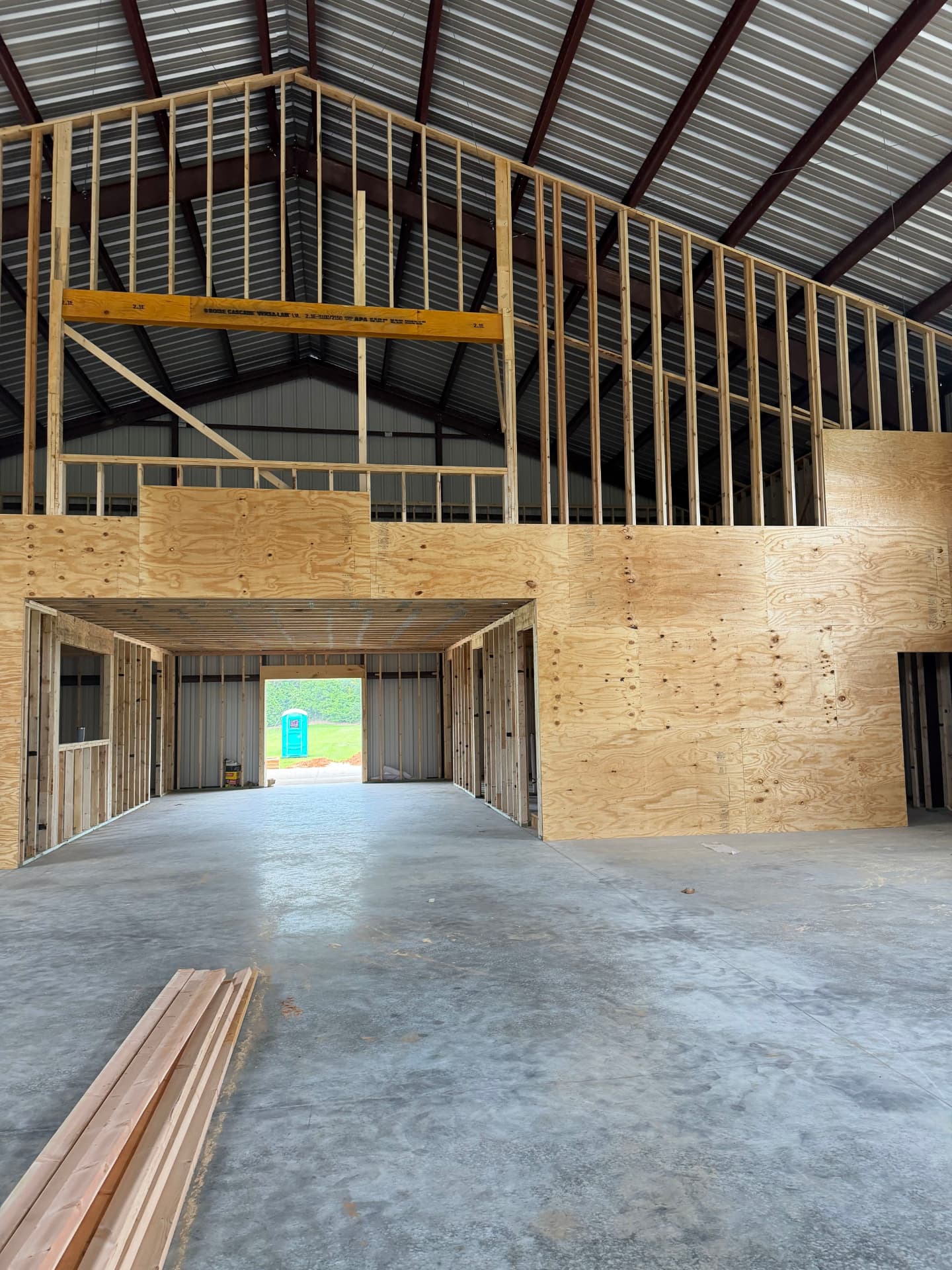 Plywood-sheathed interior walls and a framed loft inside a steel barndominium shell